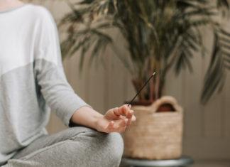 New Year, Same Me A woman meditating holding incense.