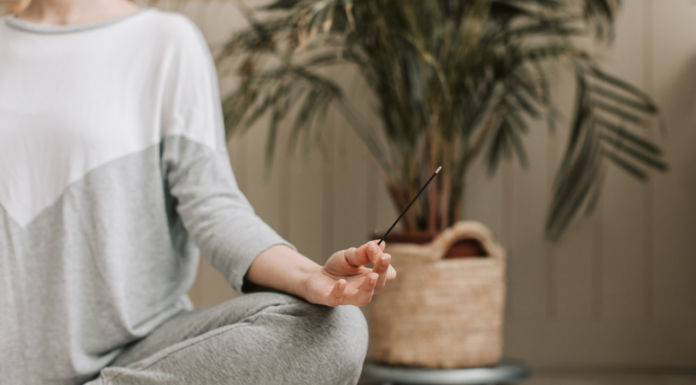 New Year, Same Me A woman meditating holding incense.