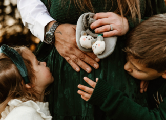A family holding a pregnant mom's belly.