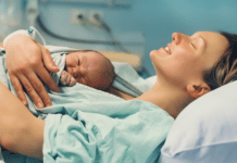 Why Don’t We Talk About Birth Stories? A woman after birth holding her newborn.