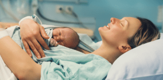 Why Don’t We Talk About Birth Stories? A woman after birth holding her newborn.