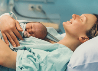 A woman after birth holding her newborn.