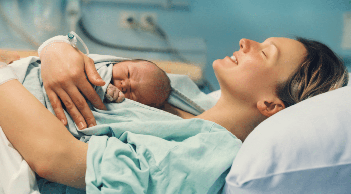 Why Don’t We Talk About Birth Stories? A woman after birth holding her newborn.