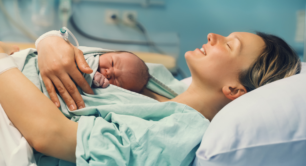 A woman after birth holding her newborn.