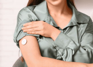 A woman wearing a continuous glucose monitor.