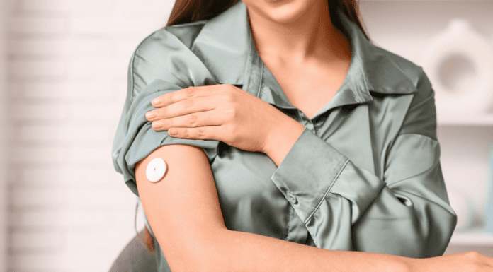 A woman wearing a continuous glucose monitor.
