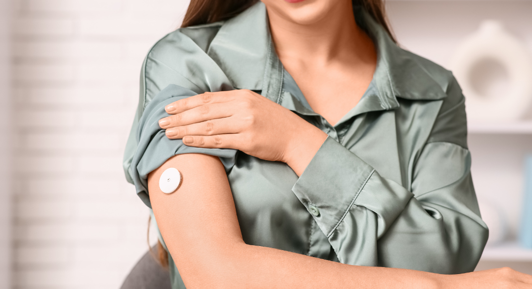 A woman wearing a continuous glucose monitor. 