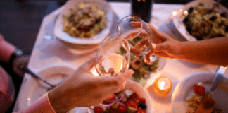 Date Night Guide {the best restaurants in Westchester County} Wine glasses being held over a table full of food.