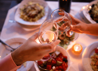 Date Night Guide {the best restaurants in Westchester County} Wine glasses being held over a table full of food.