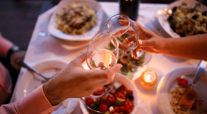 Date Night Guide {the best restaurants in Westchester County} Wine glasses being held over a table full of food.
