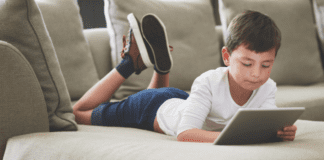Online Safety: Protecting Our Children A boy laying on the couch online.