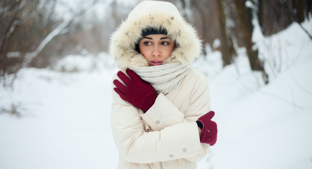 A woman bundled up outside in the middle of winter. 