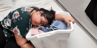 Why Mom Burnout Is So Common — and What Actually Helps A woman collapsed on a laundry basket.