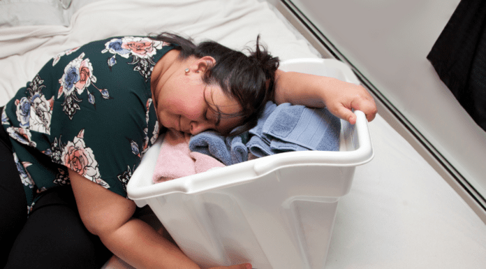 Why Mom Burnout Is So Common — and What Actually Helps A woman collapsed on a laundry basket.