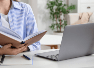 A woman reading and working on her computer.