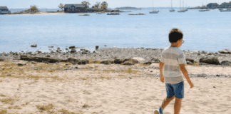 A boy walking on the beach.