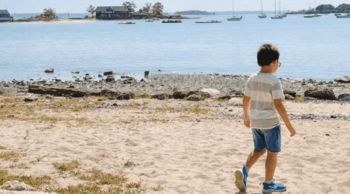 A boy walking on the beach.