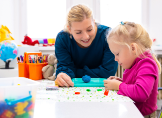 A teacher working with a student with clay.