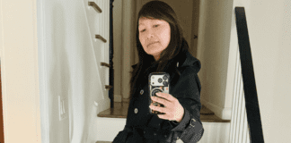 A mom taking a picture with her phone of her spring fashion.