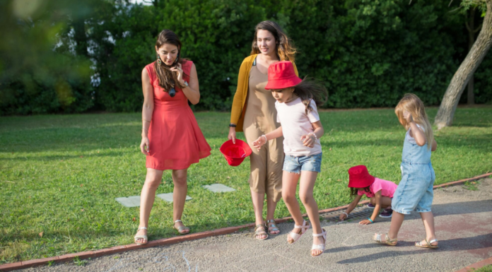 Women and kids walking down a path in the spring.