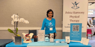 A woman standing behind a table at an expo.