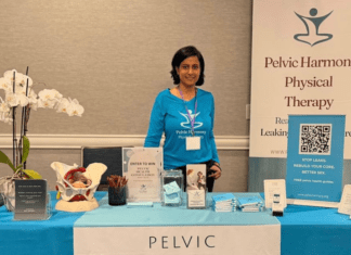 A woman standing behind a table at an expo.