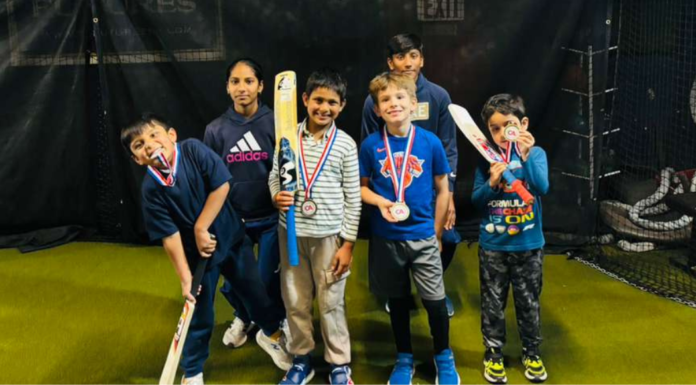 Kids with trophies after playing cricket.