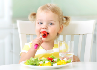 A toddler snacking on healthy foods.
