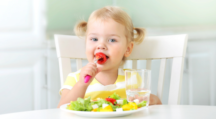 A toddler snacking on healthy foods.