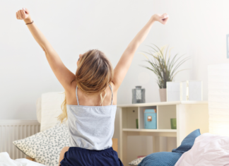 A woman embracing the day stretching her arms.