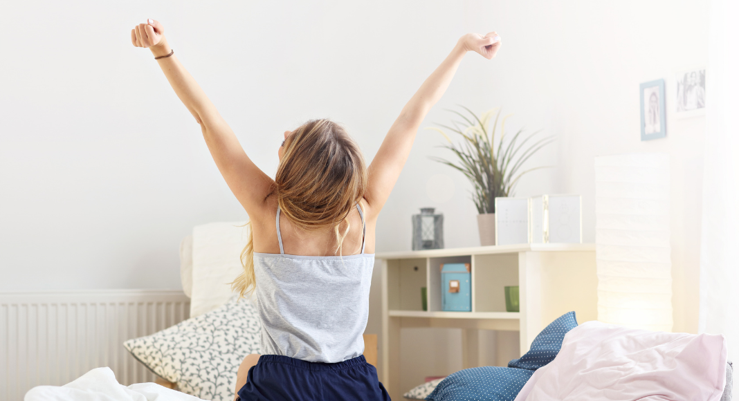 A woman embracing the day stretching her arms. 