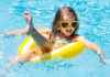 A girl floating in a tube in the pool.