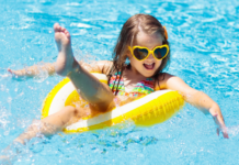 A girl floating in a tube in the pool.
