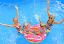 Moms in a pool with their daughters.