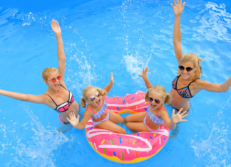 Moms in a pool with their daughters.