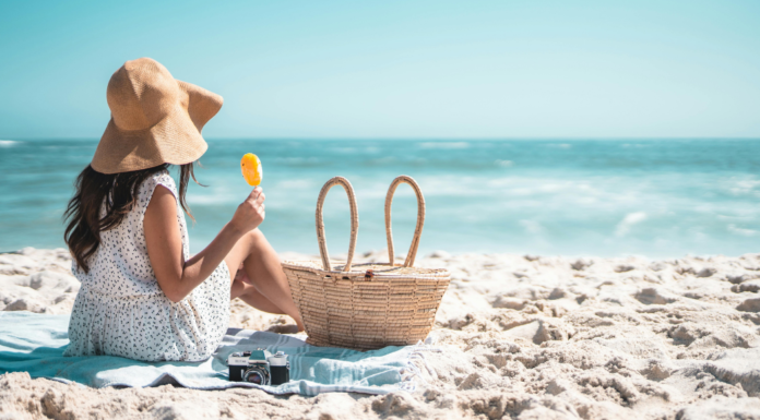 The Beach is My Happy Place A woman sitting on the beach eating a Popsicle.